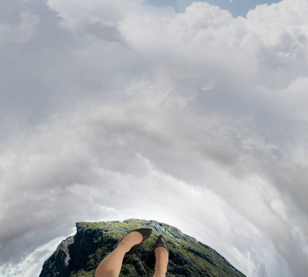 Close up of woman legs standing on the edge of rockの写真素材