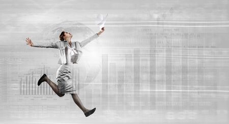 Young businesswoman in suit running at full peltの写真素材
