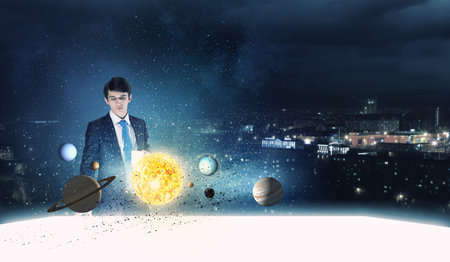Young businessman and planets of space spinning around