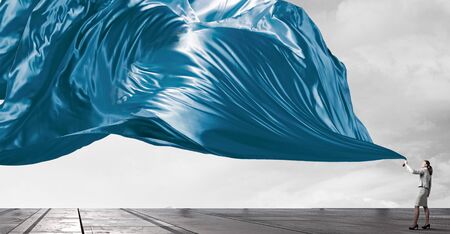 Young pretty businesswoman pulling clothing blank bannerの写真素材