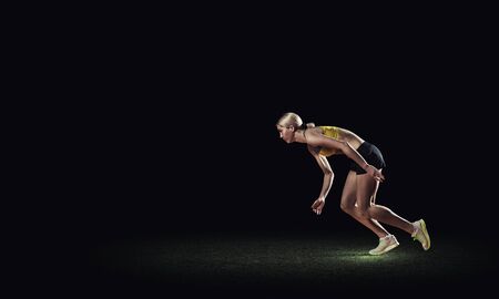 Running woman in sport wear on black backgroundの写真素材