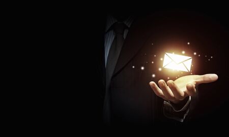 Close up of businessman holding email icon in palmの写真素材