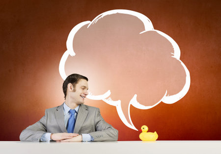 Funny businessman with yellow rubber duck toyの写真素材