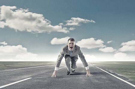 Young determined businessman standing in start positionの写真素材