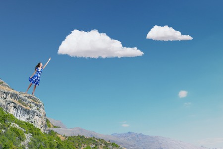 Happy young woman dreaming to fly in skyの写真素材