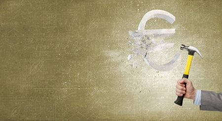 Close up of hammer in human hand breaking stone euro symbolの写真素材