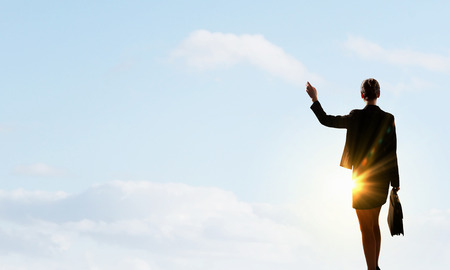 Rear view of businesswoman look at sunrise above cityの写真素材