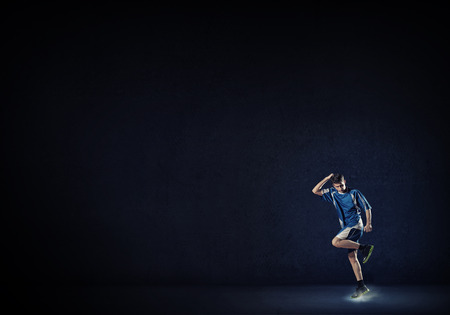 Running man in blue sport wear on black backgroundの写真素材