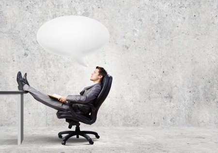 Confident handsome businessman sitting in chair and dreamingの写真素材
