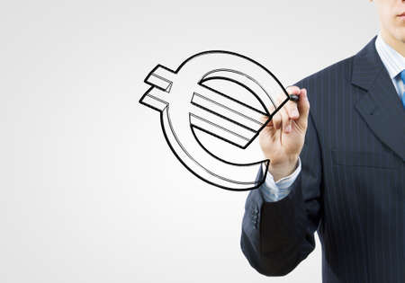 Close up of businessman drawing euro symbol with markerの写真素材
