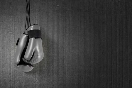 Boxing gloves hanging on nail on wallの写真素材