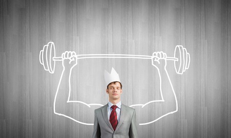 Young man with drawn strong hands lifting barbellの写真素材