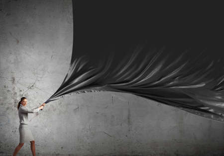 Young pretty businesswoman pulling clothing blank bannerの写真素材