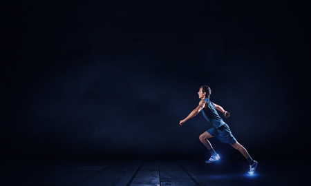 Running man in blue sport wear on black backgroundの写真素材