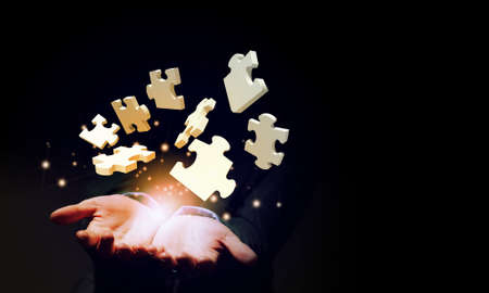 Close up of businessman holding jigsaw elements in palmの写真素材
