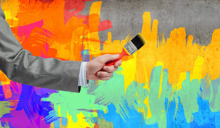 Close up of business person hand holding paint brush