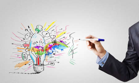 Human hand drawing light bulb isolated on white backgroundの写真素材