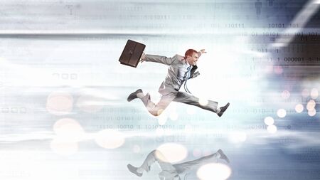 Young businessman in suit running at full peltの写真素材