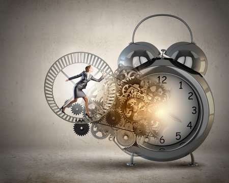 Young businesswoman running in wheel of gears mechanism