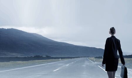 Rear view of businesswoman look at sunrise above mountainの写真素材