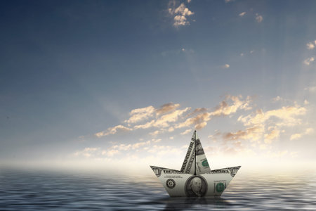 Paper ship floating on water on wavesの写真素材