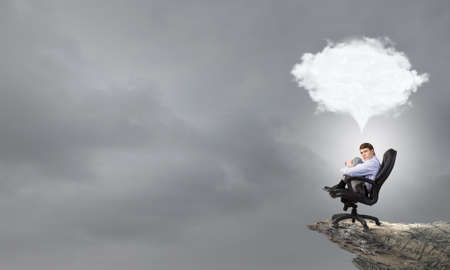 Confident handsome businessman sitting in chair and dreamingの写真素材