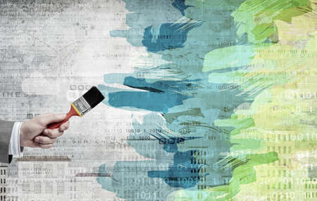 Close up of business person hand holding paint brushの写真素材