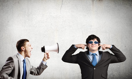 Young furious woman screaming agressively in megaphone