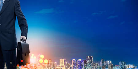 Rear view of businessman and night city at backgroundの写真素材