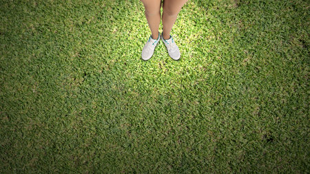 Top view of female legs in white sport shoes