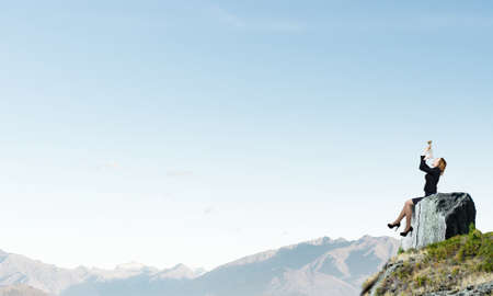 Young businesswoman in suit proclaiming something in hornの写真素材