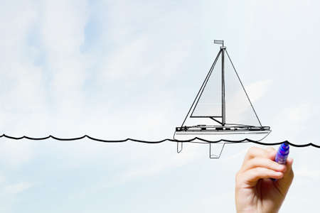 Close up of businessman hand drawing yacht with markerの写真素材