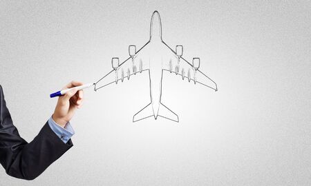 Close up of hand drawing airplane with markerの写真素材