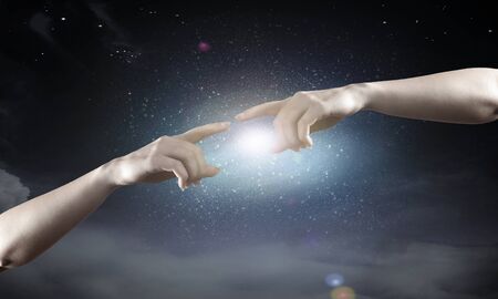 Close up of human hands reaching each other with fingersの写真素材