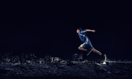 Running man in blue sport wear on black backgroundの写真素材