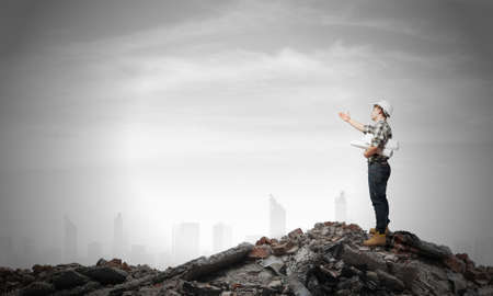 Young man builder looking thoughtfully at construction project. Idea conceptの写真素材