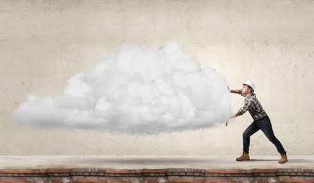 Young builder man moving big white cloudの写真素材