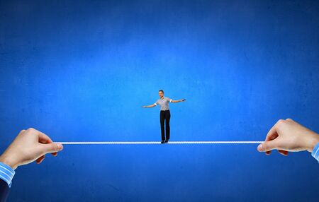 Young brave ricky businesswoman balancing on ropeの写真素材