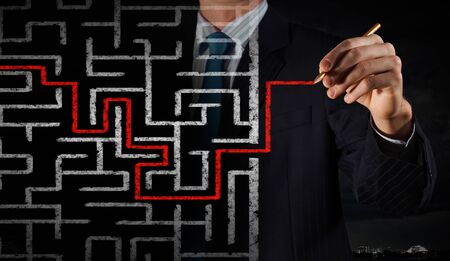 Close up of businessman drawing way out of labyrinthの写真素材