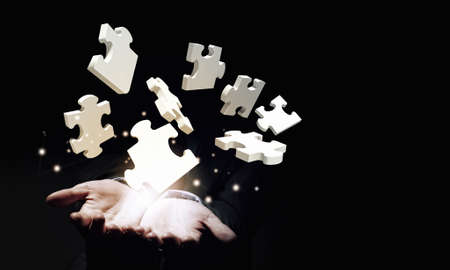 Close up of businessman holding jigsaw elements in palmの写真素材