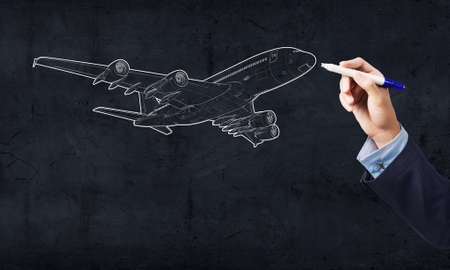 Close up of hand drawing airplane with markerの写真素材