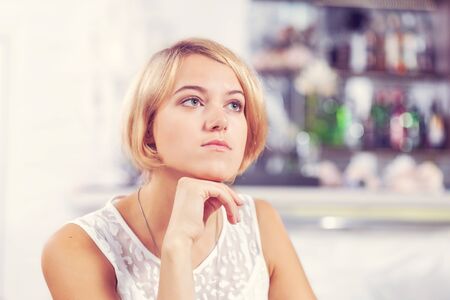 Young pretty red haired woman sitting in cafeの写真素材