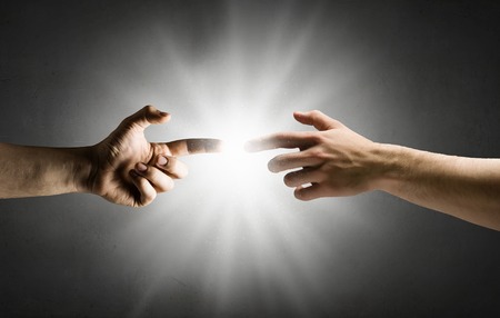 Close up of human hands reaching each other with fingersの写真素材