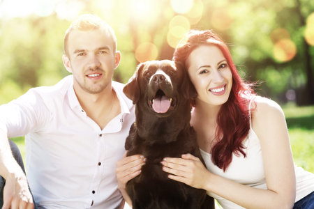 Young couple with labrador having fun and enjoying the beautiful nature
