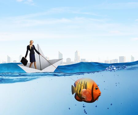 Young businesswoman and big exotic fish. Success in businessの写真素材