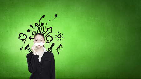 Young woman dressed up in suit and wearing fake mustacheの写真素材