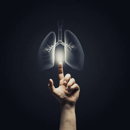 Male hand pointing on lung radiography on dark backgroundの写真素材