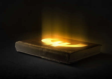 Old opened magic book with euro symbolの写真素材