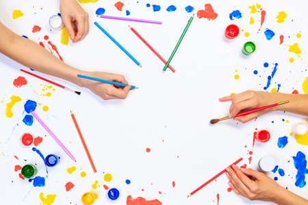 Close up of a human hands painting with gouache on white paperの写真素材