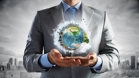 Young businessman holding Earth planet in hand. の写真素材